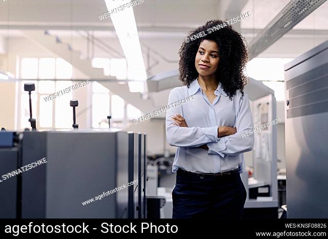 Confident businesswoman with arms crossed looking away in industry