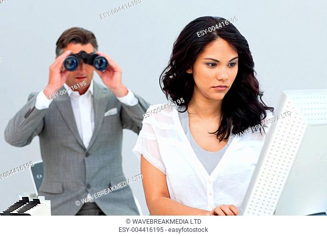 Unhappy businessman getting bored and his ma ger looking through binoculars