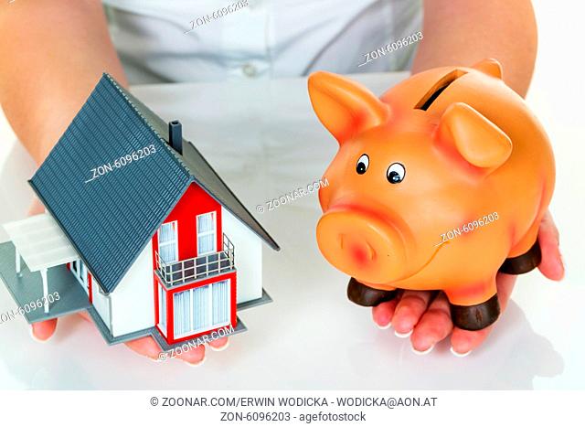 Eine Frau mit einem Haus und einem Sparschwein. Die richtige Finanzierung für den Hauskauf