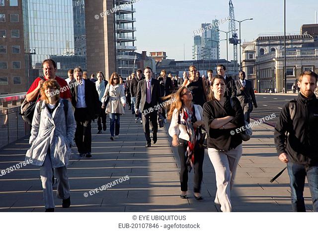 Early morning commuters crossing London Bridge towards the City Financial district