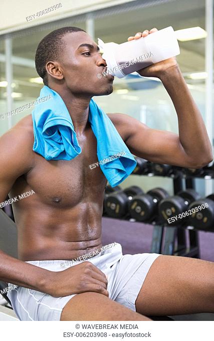 Sporty man drinking protein in gym