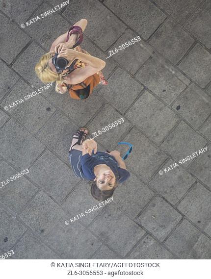 A mother and her teen looking at the famous reflective mirror in Marseille, and taking photos