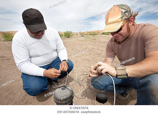Two men in special effects team tying up wires