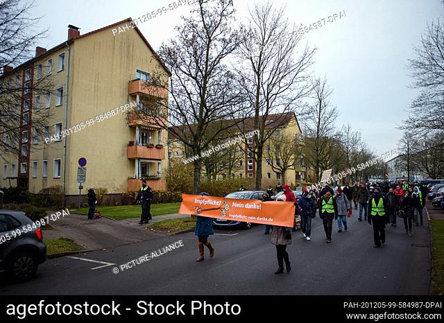 05 December 2020, Mecklenburg-Western Pomerania, Schwerin: Opponents of the government's Corona measures walk through the western suburb of Schwerin with...