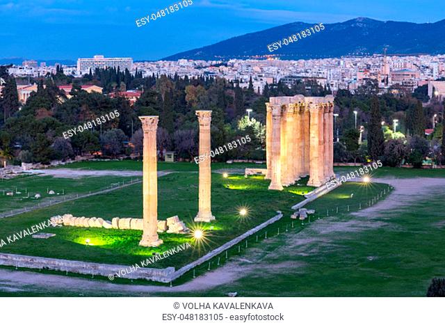 Aerial city view with Ruins and a columns of the Temple of Olympian Zeus at night, Athens, Greece