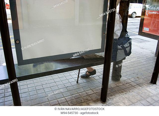 Person sitting on a bus stop