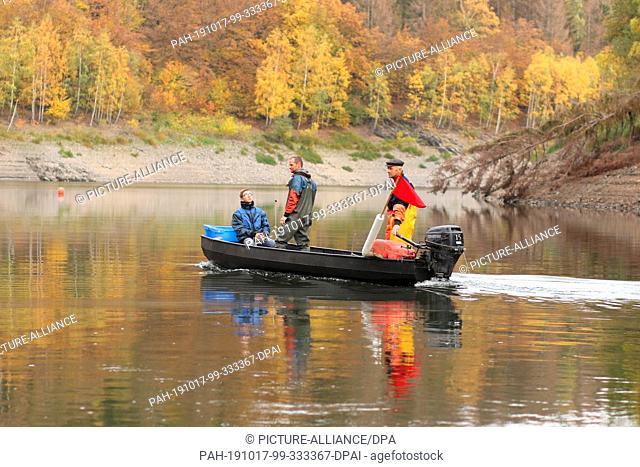 15 October 2019, Saxony-Anhalt, Hasselfelde: Professional fishermen Gernot Quaschny (r) and Sven Ahlendorf go by boat on the Rappbodetalsperre
