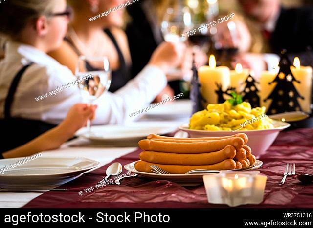 German parents and children toasting with wine and water at Christmas eve dinner