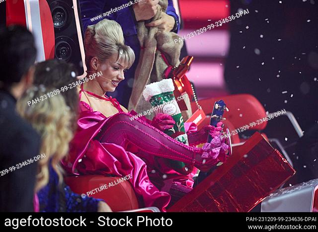 08 December 2023, Berlin: Coach Shirin David receives Christmas socks as a gift in the final of the Sat.1 show ""Voice of Germany"" and holds them to her feet