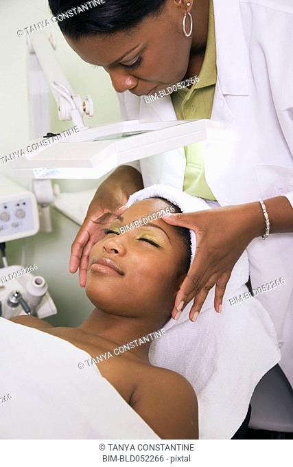 African woman receiving spa facial treatment