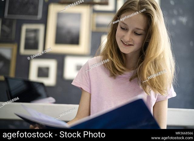 Girl reading in excersice book at home