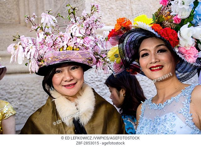 New York, NY - April 16, 2017. Two Asian women in elaborate hats on the steps of St. Patrick's Cathedral at New York's annual Easter Bonnet Parade and Festival...