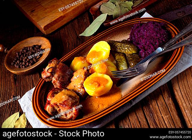 Rustic Snirtjebraten with red cabbage and cucumber