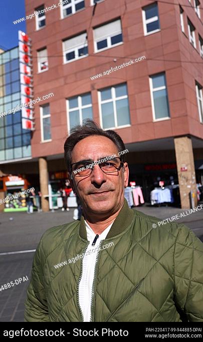 12 March 2022, Bavaria, Würzburg: Hossein Moradi is standing in front of a department store in the city center where he works as a store detective