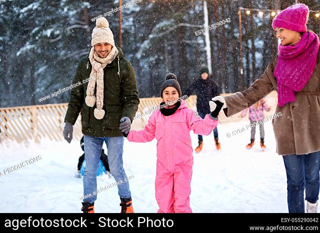happy family at outdoor skating rink in winter