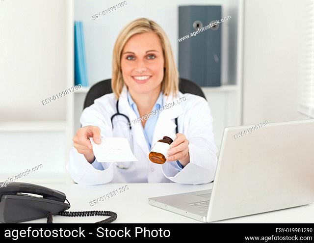Charming doctor holding prescription and medicine smiles into ca