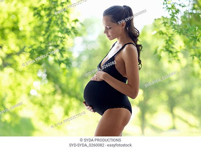 pregnant woman in lingerie over natural background