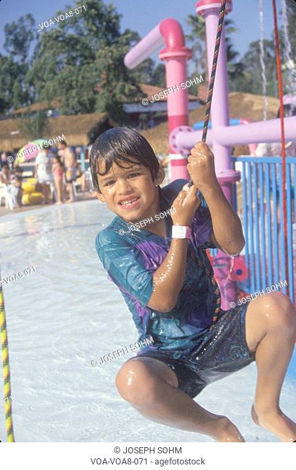 A boy on a water fountain at Raging Waters amusement park, Los Angeles, CA