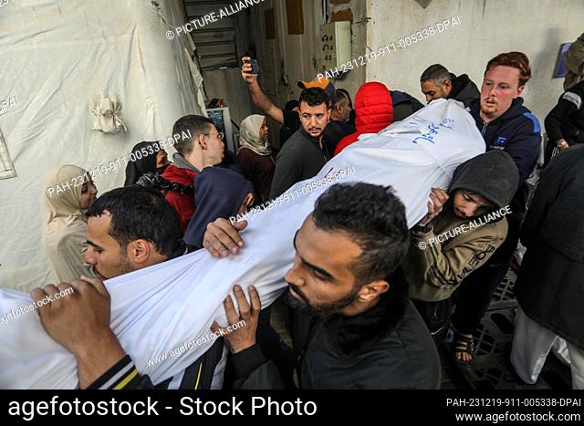 19 December 2023, Palestinian Territories, Rafah: Palestinians carry the wrapped body of a Palestinian, killed in Israeli bombardment