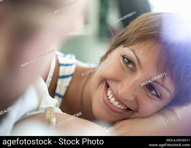 Young woman resting with man in bedroom at home