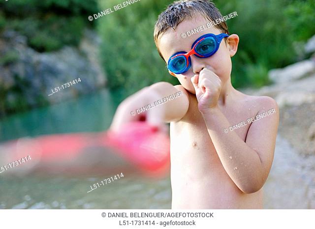 boy with underwater glasses playing by the river, Villahermosa river, Ludiente, Castellón, Spain