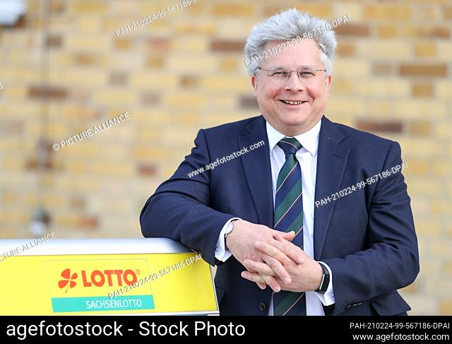 23 February 2021, Saxony, Leipzig: Frank Schwarz, Managing Director of Sächsische Lotto-GmbH, stands next to a logo of Sachsenlotto