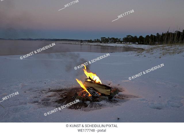 Camp fire in the snow on a beach