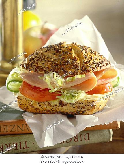 Sliced turkey, tomato, cucumber & lettuce in bread roll with seeds