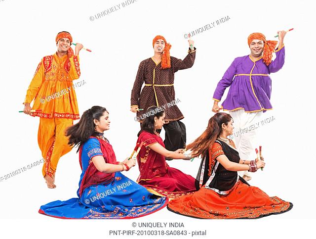 Men and women performing dandiya