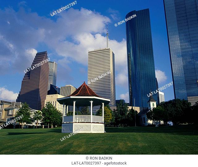Band stand in Sam Houston park. High-rise buildings behind. Green grass