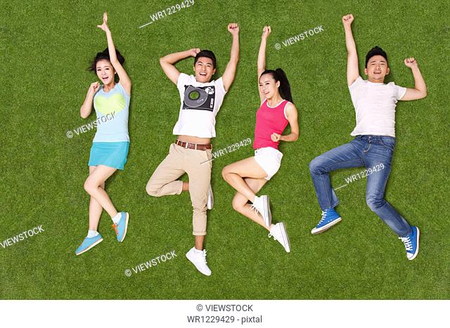 Young people lying on grass