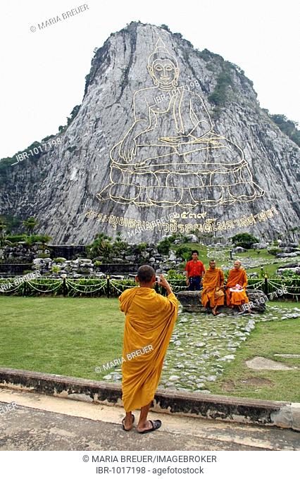 Monks taking a photograph of a Buddha image on a cliff, Phra Puttha Maha Wachira Uttamopat Satsada, largest image of Buddha in the world, Khao Chi Chan