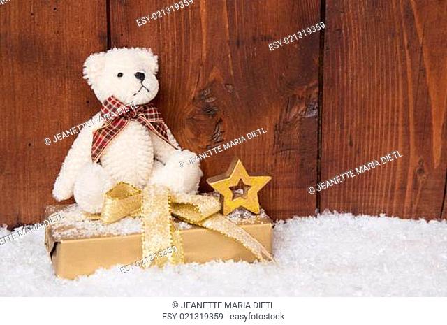 White teddy-bear sitting on present box for christmas