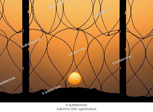 View of Setting Sun From Behind Concertina Wire at Al Taqaddum Air Base in Iraq's Al Anbar Province