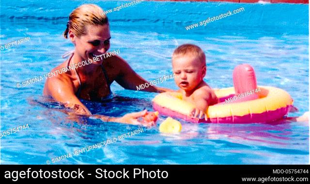 Italian television presenter and showgirl Simona Ventura in the pool with her son Niccolò. 1999