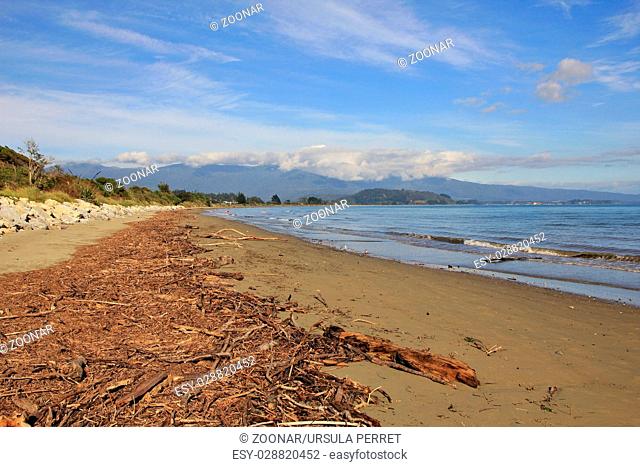 Scene after heavy rainfall, driftwood at Pohara Beach