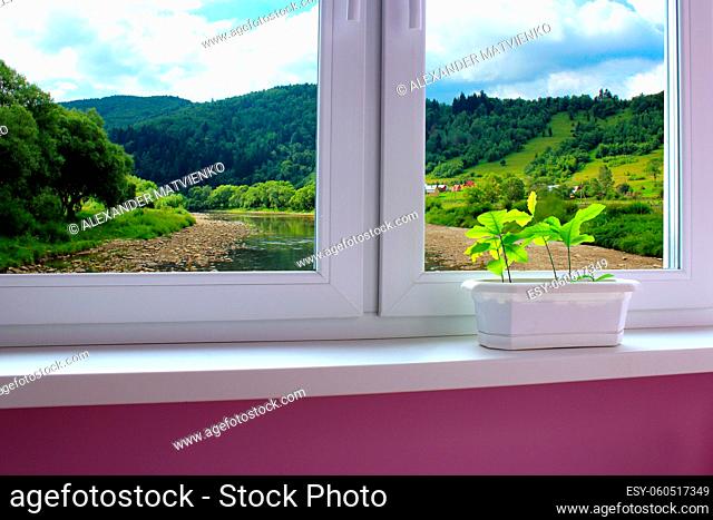 cozy room with window overlooking the beautiful summer mountain landscape