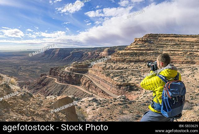 Photographer, tourist at the Moki Dugway, serpentines through steep face of the Cedar Mesa, view of the Valley of the Gods, Bears Ears National Monument