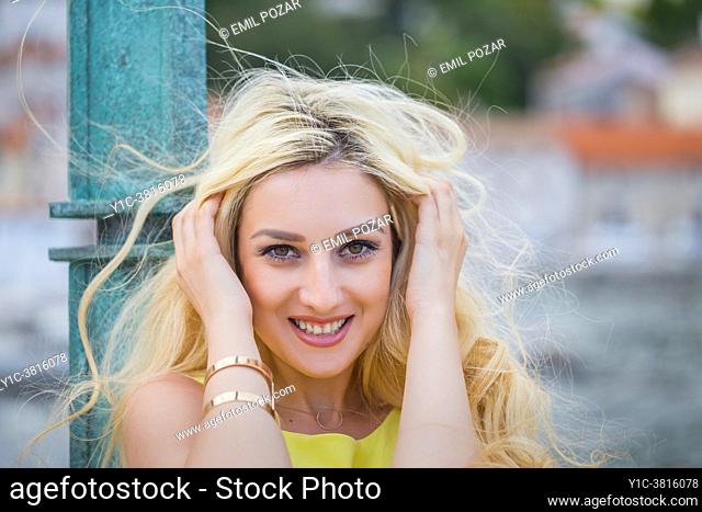 Young woman hands holding hair because of wind
