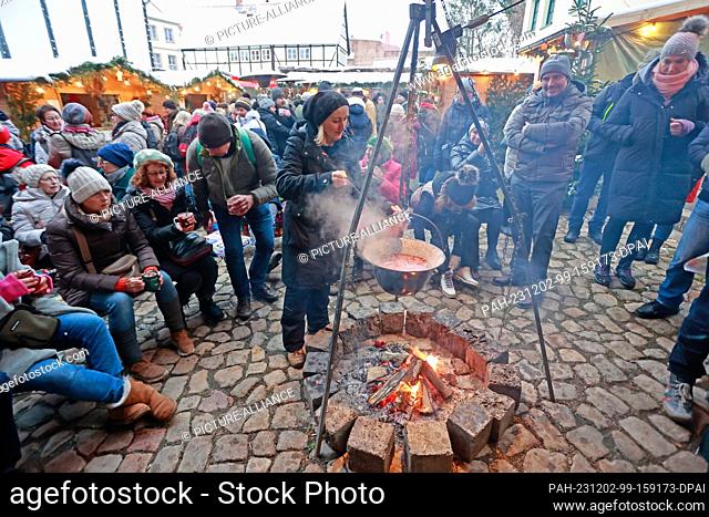 02 December 2023, Saxony-Anhalt, Quedlinburg: Warm drinks are served at a small Christmas market in a courtyard in the Advent town of Quedlinburg