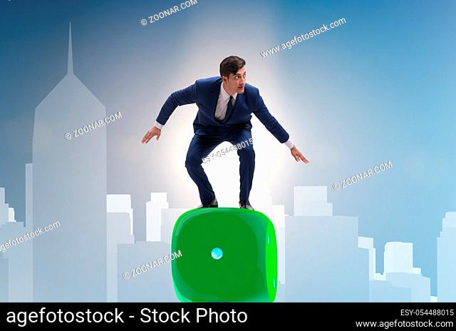 Businessman balancing on top of dice stack in uncertainty concept