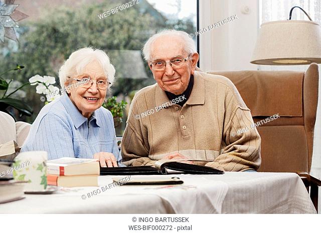 Senior couple watching old photographs at home