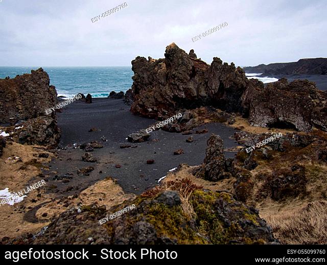Rugged lava rocks on a black sandy beach in Iceland
