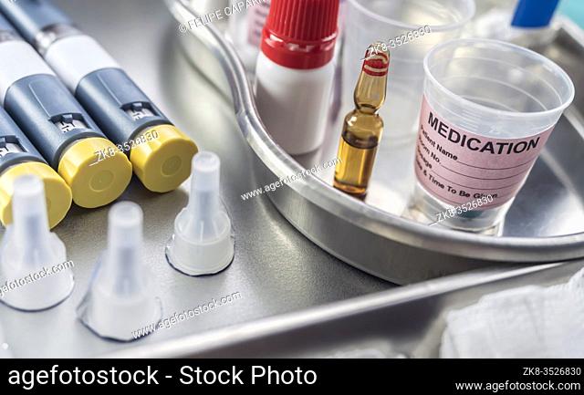 Syringes of insulin medication next to medicine vials prepared in hospital, conceptual image,