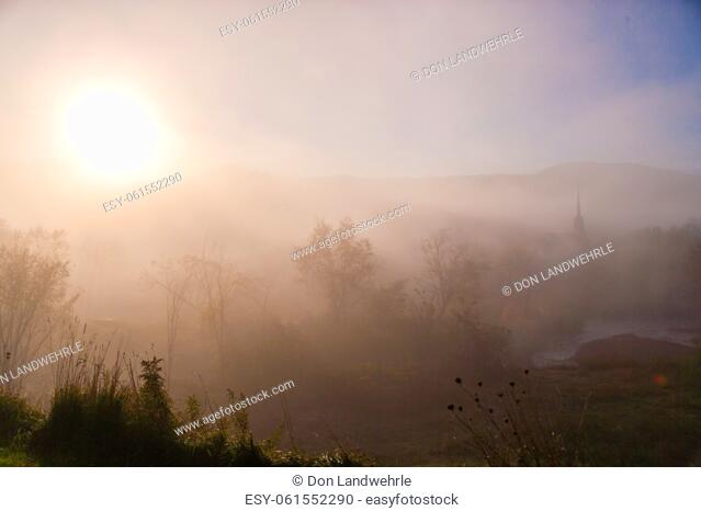 Sunrise over the New England town of Stowe Vermont on a foggy morning