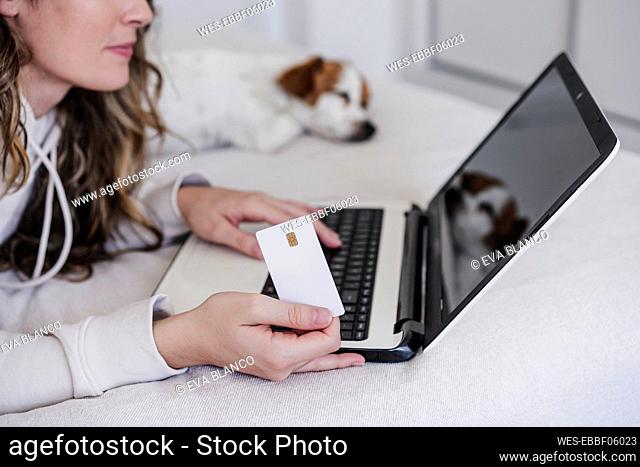 Young woman with laptop shopping online with credit card