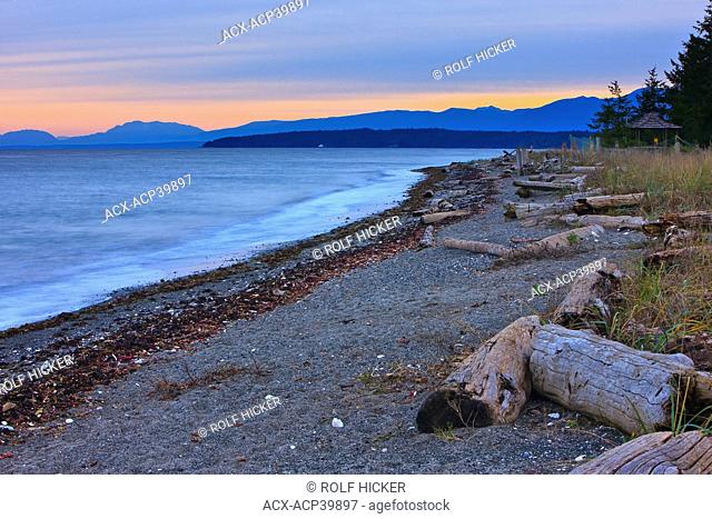 Sunset over the beach at Fillongley Provincial Park on the eastern shores of Denman Island, Strait of Georgia, British Columbia, Canada