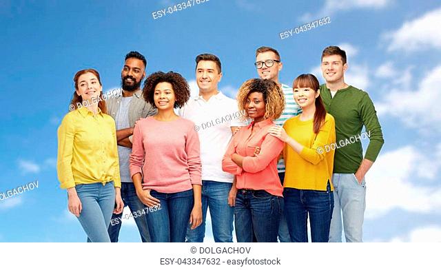 diversity, race, ethnicity and people concept - international group of happy smiling men and women over blue sky background