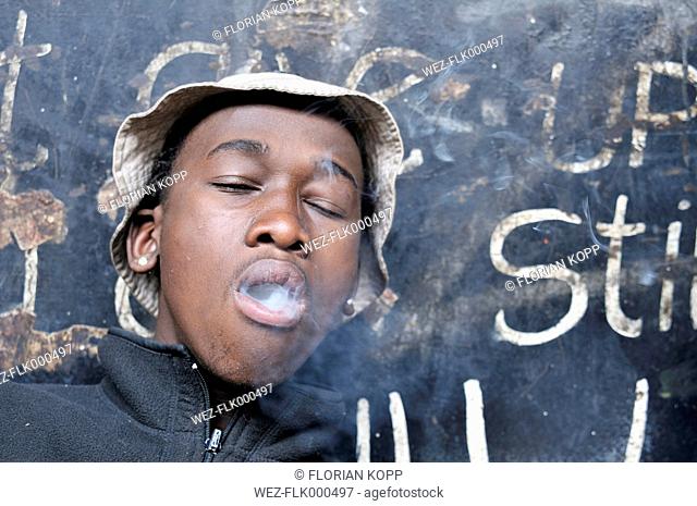 South Africa, Johannesburg, Hillbrow, street kid smoking a joint