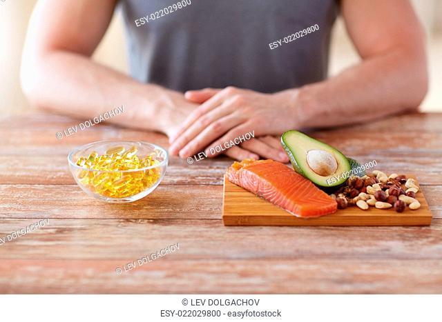 healthy eating, diet and people concept - close up of male hands with food rich in protein on cutting board on table